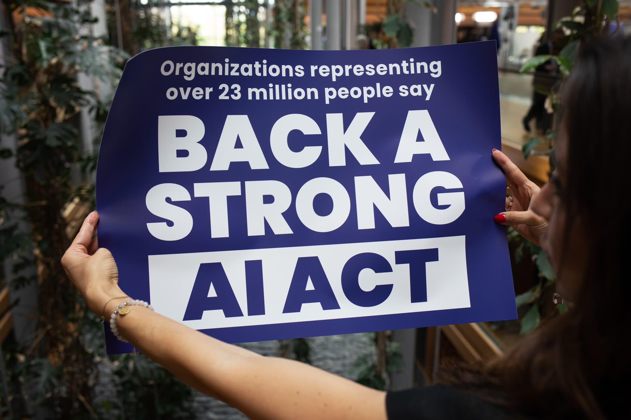 A campaigner at the European Parliament in Strasbourg holds a sign reading 'Back a strong AI Act'